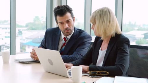Two Business People Talk Project Strategy at Office