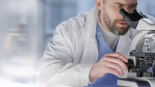 Man Uses Microscope for Medical Research in Lab
