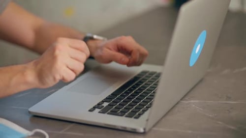 Adult Using Laptop, Closes Computer and Moves Mask