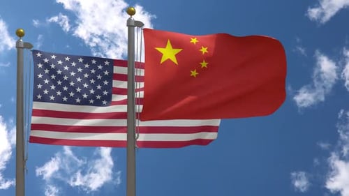 Waving United States and China Flags on Flagpoles Against Blue Sky