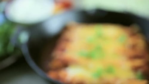 Enchiladas in Skillet Topped with Cheese and Onions