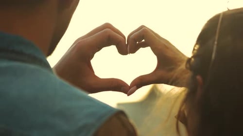 Close Up Young Couple Making Heart Shape with Hands