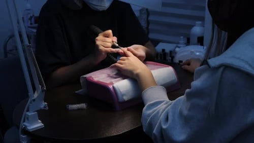 Nail Technician Giving a Manicure to a Client
