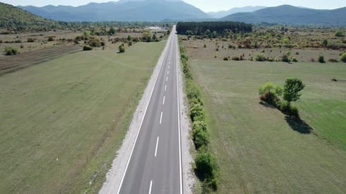 Empty Asphalt Road on the Plateau Between Green Fields Highland Way Aerial View