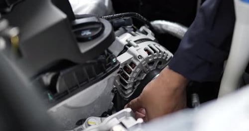 Asian Man mechanic inspection shine a torch car engine checking bug in engine