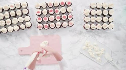 Flache Lage. Schritt für Schritt. Kleines Mädchen übt Buttercreme-Zuckerguss in ein Schneidebrett