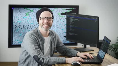 Man Working at Desk with Computers and Code