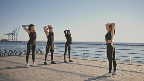 Group of Young Active People Warming Up on Pier with Sport Coach Training Together on Pier at