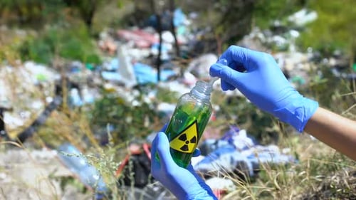 Scientist testing toxic waste in landfill area