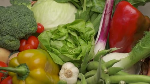 Various mixed vegetables green salad lettuce, red peppers, broccoli, tomato, carrots rotating. Medit