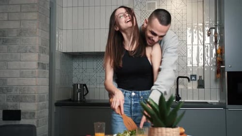 Affectionate Couple Cooking Together in Modern Kitchen