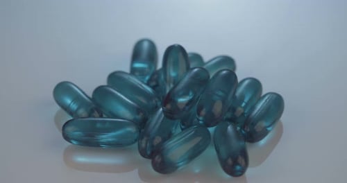 Blue Translucent Gel Capsules Rotating in Close-Up