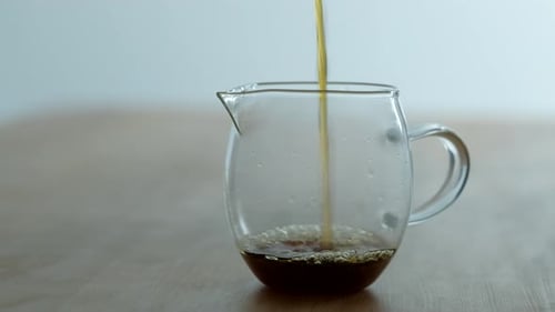 Close Up of Coffee Pouring Into Glass Container