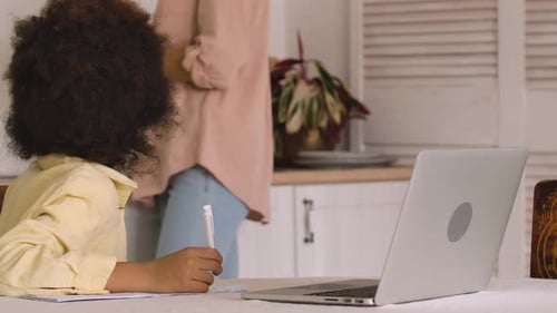 Child Studies with Mom at Home on Laptop