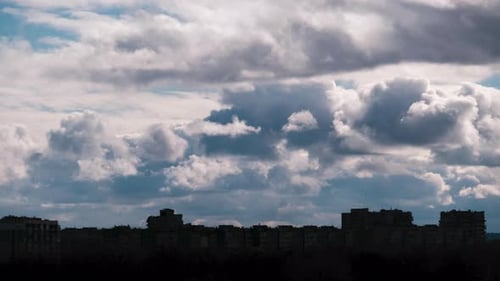 Timelapse of Cumulus Clouds Moves Above the Silhouettes of HighRise Buildings