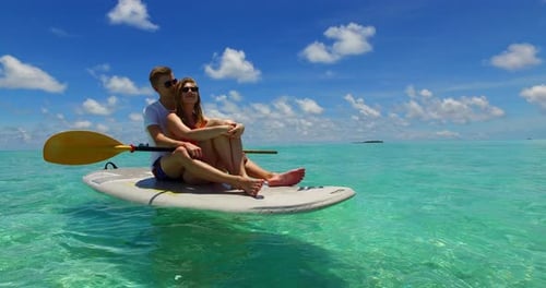 Happy man and woman on honeymoon vacation spend quality time on beach on sunny white sandy