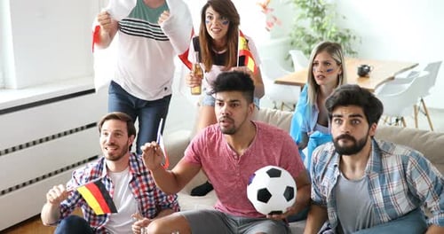 Amigos felices o fanáticos del fútbol viendo fútbol en la televisión y celebrando la victoria en casa