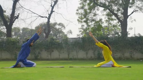 Pose estendida de ioga infantil ou Prasarita Balasana está sendo feito por um casal indiano em uma roupa indiana