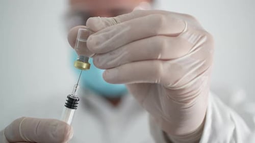 Close-up of Medical Professional Drawing Liquid into Syringe