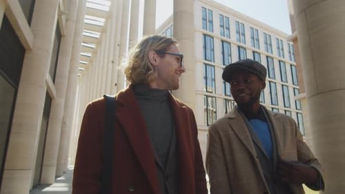 Men Talking While Walking in Urban Location