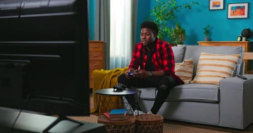 Man Playing Video Game on Couch at Home