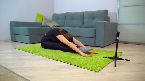 Woman Stretching on Mat in Living Room
