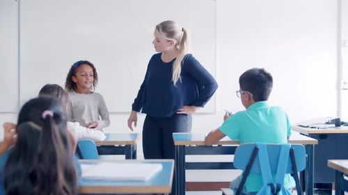 Female School Teacher Asking Questions To Mix Raced Pupil