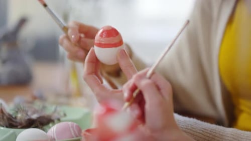 Mère et enfant méconnaissables décorant des œufs de Pâques