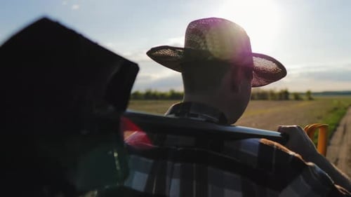 Farmer Walking Through Field Carrying a Shovel