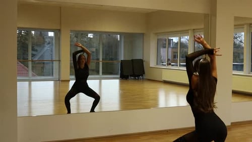 Young Woman Dancing in Studio with Mirrored Wall