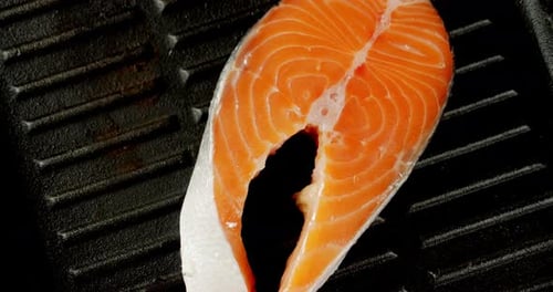The Salmon Steak in the Pan Slowly Rotates
