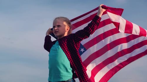 Young Girl Holding American Flag Flowing in Wind