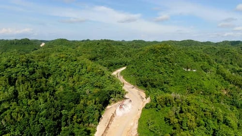 Limpiar el paisaje forestal para construir una nueva carretera sinuosa en Indonesia, vista aérea