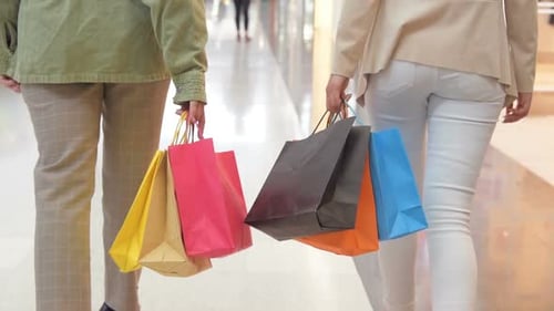 Beine von Shopaholics mit Einkaufstüten Walking Down Mall. Zeitlupe. Weibliche Frauen beim Gehen