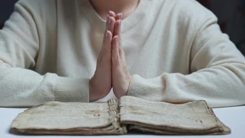 Unerkennbare Frau liest altes altes Buch Heilige Bibel und betet