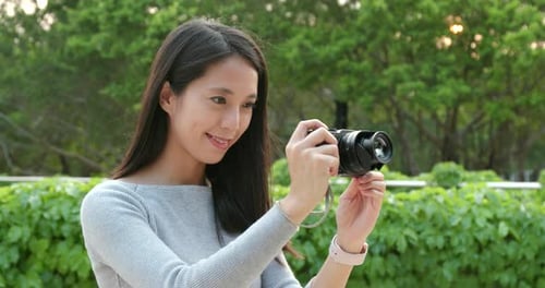 Young Woman taking photo on camera in the park