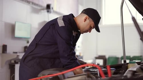Car Mechanic Using Wrench to Repair the Engine in a Car Service