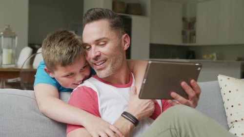 Dad and Son Relaxing with Tablet at Home