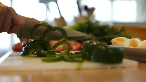 Hands Chopping Green Pepper on Cutting Board