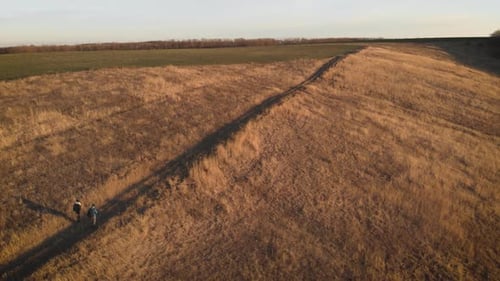 Happy Couple Man and Woman Tourist at Top of Mountain at Sunset Outdoors During a Hike. Silhouettes