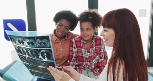 Doctor Explains X-Ray to Adult and Child