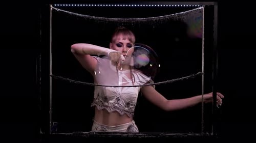 Woman Making Giant Soap Bubbles in Dark Environment