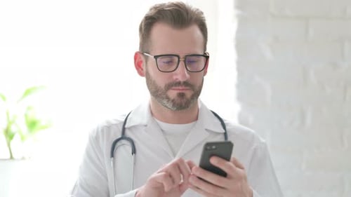 Doctor Uses Smartphone in Bright Hospital Setting