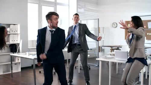 Des collègues enthousiastes dansant dans le bureau