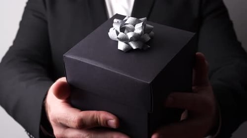 Man Holding Black Gift Box with Silver Bow