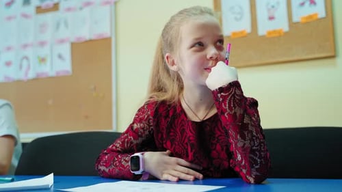 Girl with Pen Thinking in Classroom