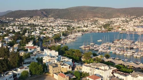 Luftdrohne fliegt an einem Sommernachmittag bei Sonnenuntergang über den Yachthafen von Bodrum voller Segelboote