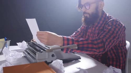 Male Typing on a Vintage Typewriter at Desk