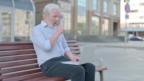 Senior Man Using Laptop While Sitting Outdoors