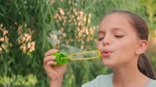 Close Up Of Pretty Girl Blowing Soap Bubbles
